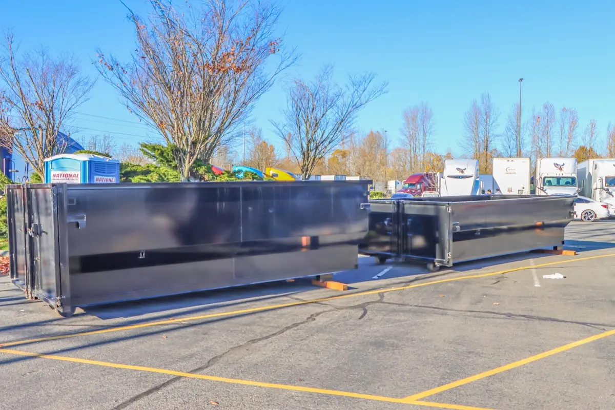 Professional dumpster rental service with roll-off container on residential driveway in West Bend